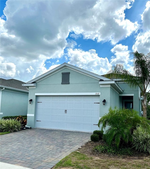 2042 Key Bay Trl, Kissimmee, FL 34747 - view of front of home with stucco siding, a garage, and decorative driveway