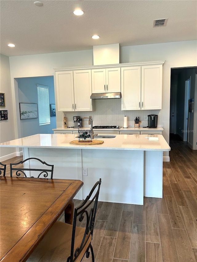 2042 Key Bay Trl, Kissimmee, FL 34747 - kitchen featuring under cabinet range hood, light countertops, dark wood-type flooring, and recessed lighting