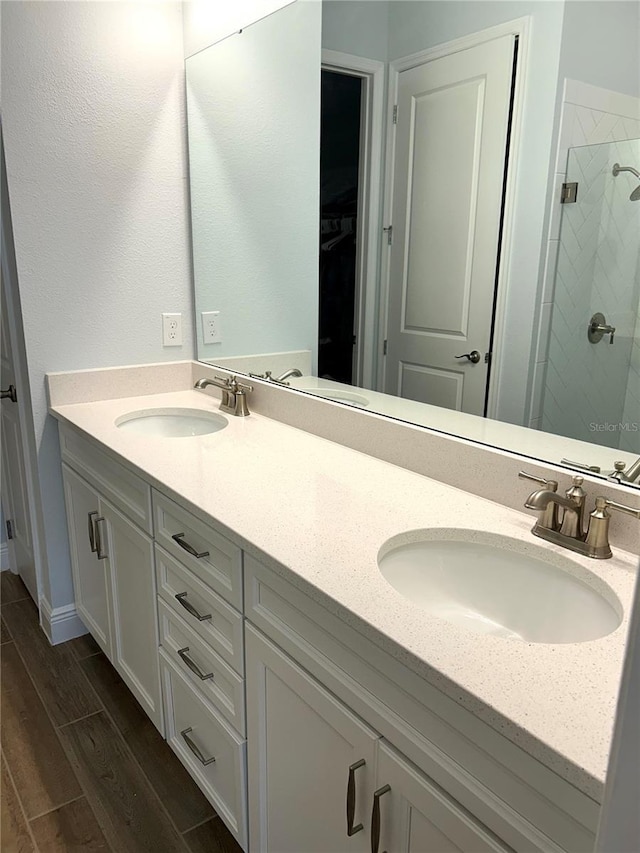 2042 Key Bay Trl, Kissimmee, FL 34747 - bathroom with double vanity, a shower stall, wood finished floors, and a spacious closet