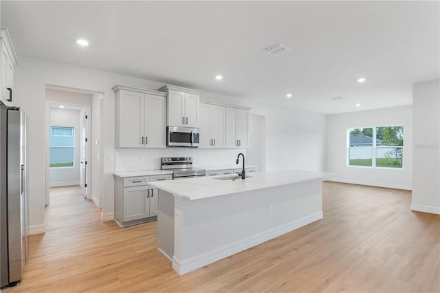 5908 SW 115 Street Rd, Ocala, FL 34476 - kitchen featuring stainless steel appliances, backsplash, light wood-type flooring, recessed lighting, and an island with sink