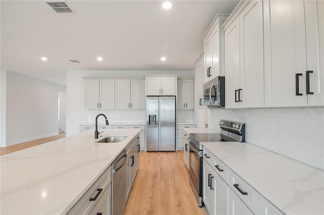 5908 SW 115 Street Rd, Ocala, FL 34476 - kitchen with stainless steel appliances, recessed lighting, light wood-style floors, decorative backsplash, and light stone counters