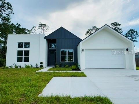 2664 SW De Groodt Rd, Palm Bay, FL 32908 - view of front of home with an attached garage, driveway, a front yard, and board and batten siding