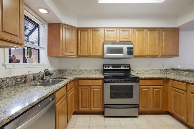 940 Douglas Ave Unit 159, Altamonte Springs, FL 32714 - kitchen with stainless steel appliances, light tile patterned flooring, light stone countertops, and brown cabinetry