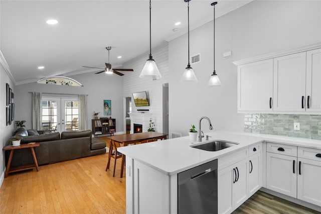 144 Bridgeton St, Davenport, FL 33896 - kitchen with stainless steel dishwasher, ceiling fan, a peninsula, light wood-style flooring, and light countertops