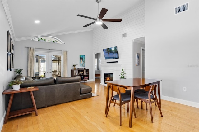 144 Bridgeton St, Davenport, FL 33896 - dining room with a fireplace, light wood-type flooring, a ceiling fan, high vaulted ceiling, and crown molding