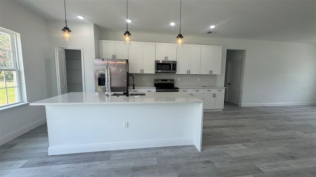 482 Marion Oaks Mnr, Ocala, FL 34473 - kitchen featuring appliances with stainless steel finishes, a kitchen island with sink, white cabinets, healthy amount of natural light, and recessed lighting