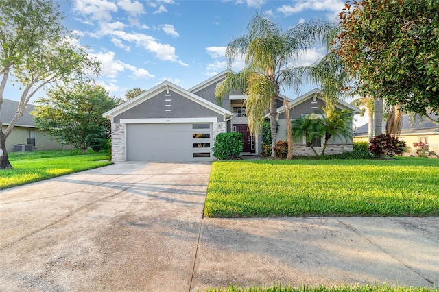 1315 Vista Del Lago Blvd, Dundee, FL 33838 - view of front of house featuring concrete driveway, a front yard, a garage, stucco siding, and stone siding