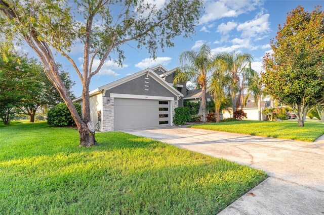 1315 Vista Del Lago Blvd, Dundee, FL 33838 - view of front of property featuring stucco siding, concrete driveway, a front yard, and a garage