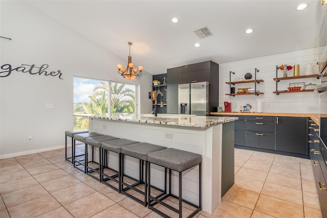 1315 Vista Del Lago Blvd, Dundee, FL 33838 - kitchen with stainless steel fridge with ice dispenser, open shelves, vaulted ceiling, a chandelier, and a breakfast bar