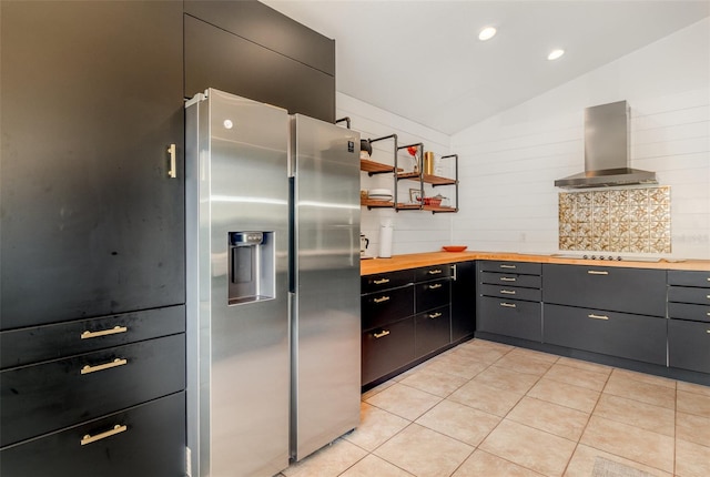 1315 Vista Del Lago Blvd, Dundee, FL 33838 - kitchen with wall chimney range hood, stainless steel fridge, butcher block counters, vaulted ceiling, and black electric cooktop