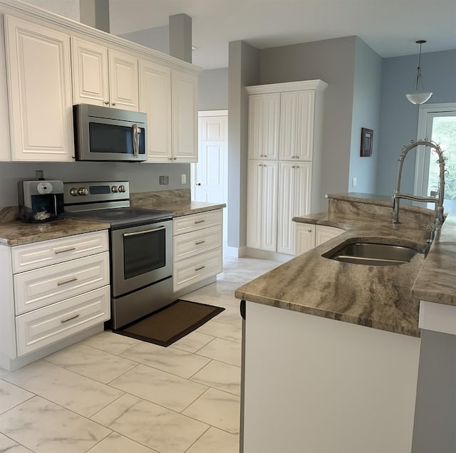 1784 Providence Blvd, Deltona, FL 32725 - kitchen with stainless steel appliances, light marble finish flooring, hanging light fixtures, white cabinets, and dark stone countertops