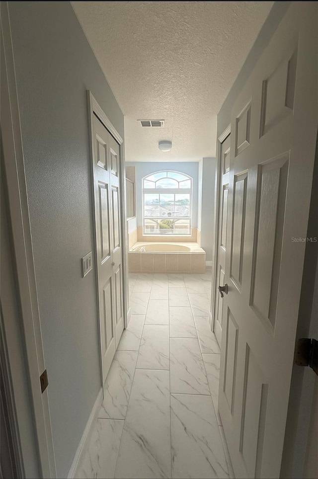 1784 Providence Blvd, Deltona, FL 32725 - corridor with light marble finish floors and a textured ceiling