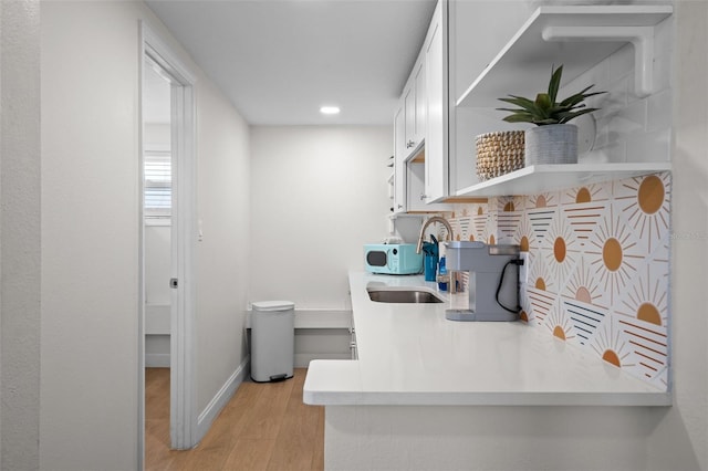 402 S Orlando Ave, Cocoa Beach, FL 32931 - kitchen with light wood-type flooring, white cabinetry, recessed lighting, white microwave, and light countertops