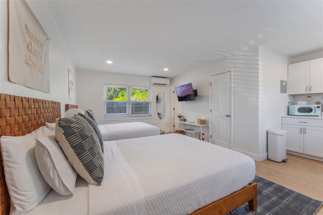 402 S Orlando Ave, Cocoa Beach, FL 32931 - bedroom with an AC wall unit, light wood-type flooring, attic access, and recessed lighting
