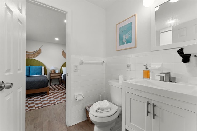 402 S Orlando Ave, Cocoa Beach, FL 32931 - ensuite bathroom with tile walls, vanity, wood finished floors, wainscoting, and recessed lighting