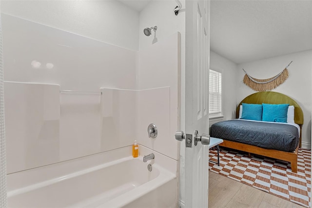 402 S Orlando Ave, Cocoa Beach, FL 32931 - ensuite bathroom with bathing tub / shower combination and wood finished floors