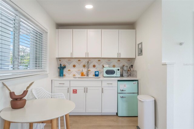 402 S Orlando Ave, Cocoa Beach, FL 32931 - kitchen featuring freestanding refrigerator, white microwave, tasteful backsplash, light countertops, and recessed lighting