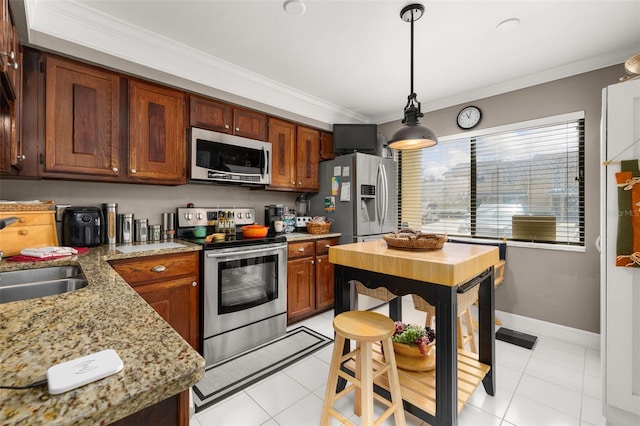 2208 Mcmahon Ct Unit 1033, Orlando, FL 32812 - kitchen featuring appliances with stainless steel finishes, ornamental molding, light tile patterned floors, hanging light fixtures, and light stone counters