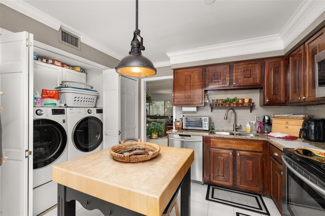 2208 Mcmahon Ct Unit 1033, Orlando, FL 32812 - kitchen featuring separate washer and dryer, stainless steel appliances, ornamental molding, hanging light fixtures, and light tile patterned floors