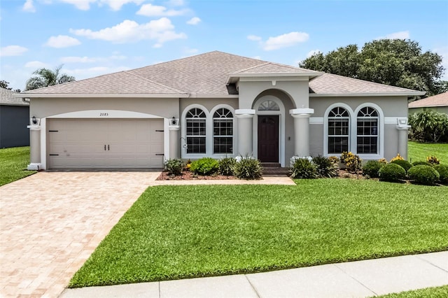 2085 Stone Cross Cir, Orlando, FL 32828 - view of front facade featuring a front lawn, decorative driveway, stucco siding, and a garage