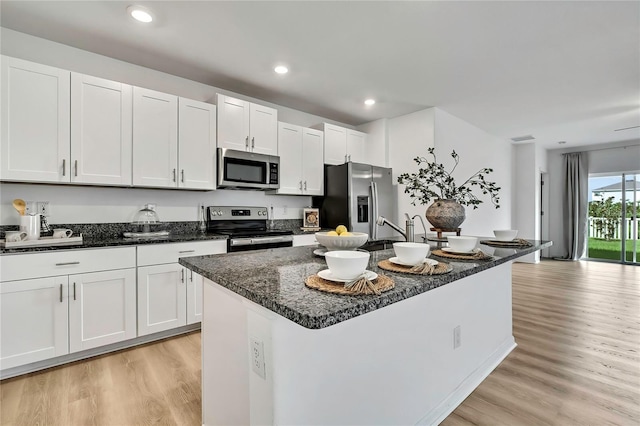 9937 Aqua Miles Path, Wesley Chapel, FL 33545 - kitchen with stainless steel appliances, light wood-type flooring, a center island with sink, white cabinets, and recessed lighting
