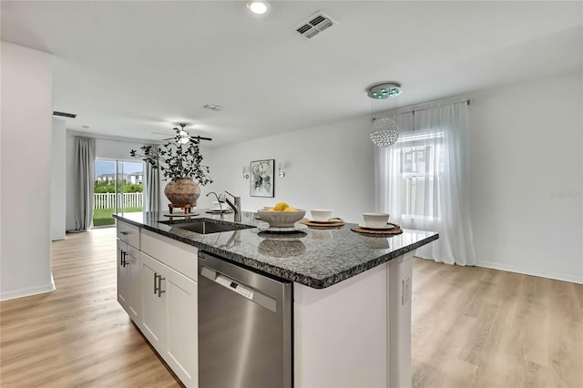 9937 Aqua Miles Path, Wesley Chapel, FL 33545 - kitchen featuring stainless steel dishwasher, dark stone counters, light wood-type flooring, a center island with sink, and white cabinets