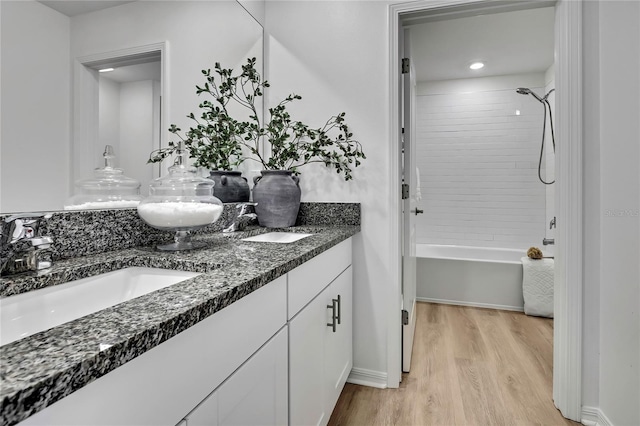 9937 Aqua Miles Path, Wesley Chapel, FL 33545 - bathroom with double vanity, wood finished floors, and tub / shower combination