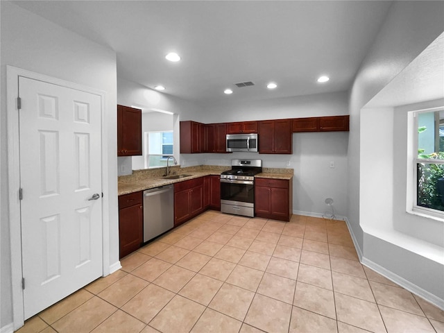 16006 Stags Leap Dr, Lutz, FL 33559 - kitchen featuring stainless steel appliances, recessed lighting, light stone countertops, light tile patterned floors, and reddish brown cabinets
