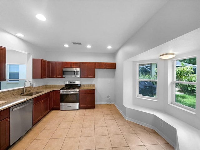 16006 Stags Leap Dr, Lutz, FL 33559 - kitchen featuring appliances with stainless steel finishes, recessed lighting, light tile patterned floors, light stone counters, and dark brown cabinets