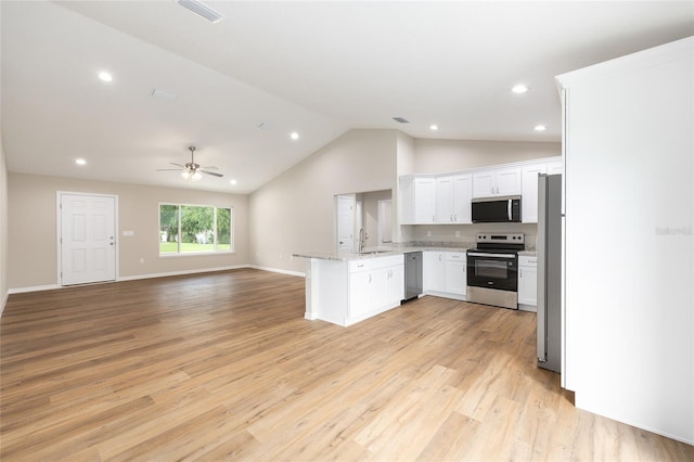 1059 NE 130th Ter, Silver Springs, FL 34488 - kitchen featuring appliances with stainless steel finishes, open floor plan, a peninsula, lofted ceiling, and white cabinets
