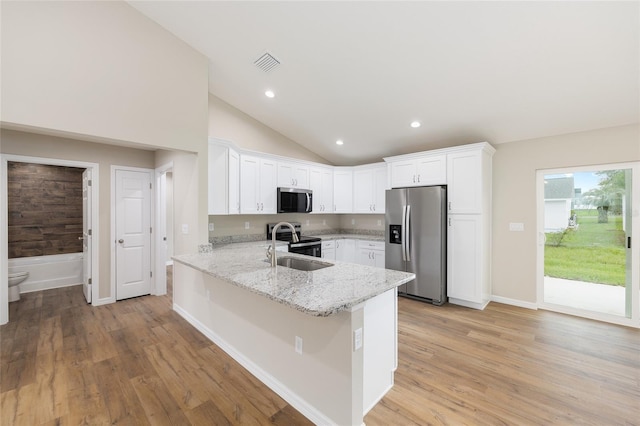 1059 NE 130th Ter, Silver Springs, FL 34488 - kitchen featuring stainless steel appliances, a peninsula, white cabinetry, light stone counters, and light wood-style floors