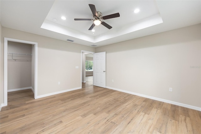 1059 NE 130th Ter, Silver Springs, FL 34488 - unfurnished bedroom with a tray ceiling, recessed lighting, light wood-type flooring, a spacious closet, and a closet
