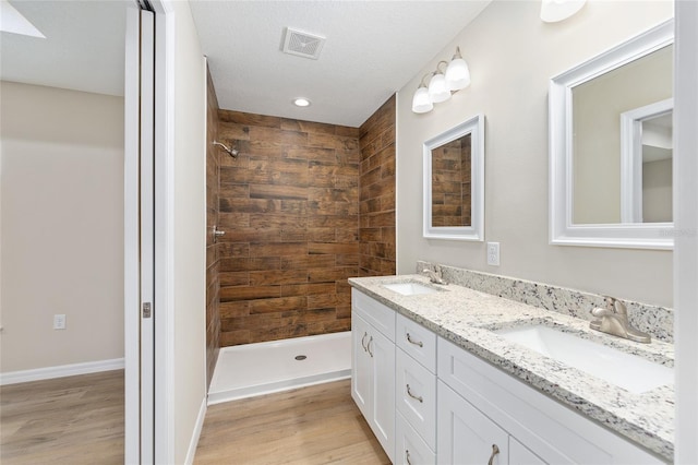 1059 NE 130th Ter, Silver Springs, FL 34488 - full bathroom with double vanity, tiled shower, wood finished floors, and recessed lighting