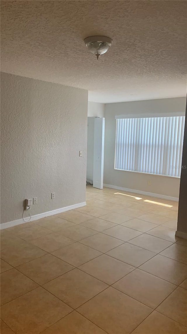 5725 Gatlin Ave Unit 315, Orlando, FL 32822 - empty room with a textured ceiling, a textured wall, and light tile patterned floors