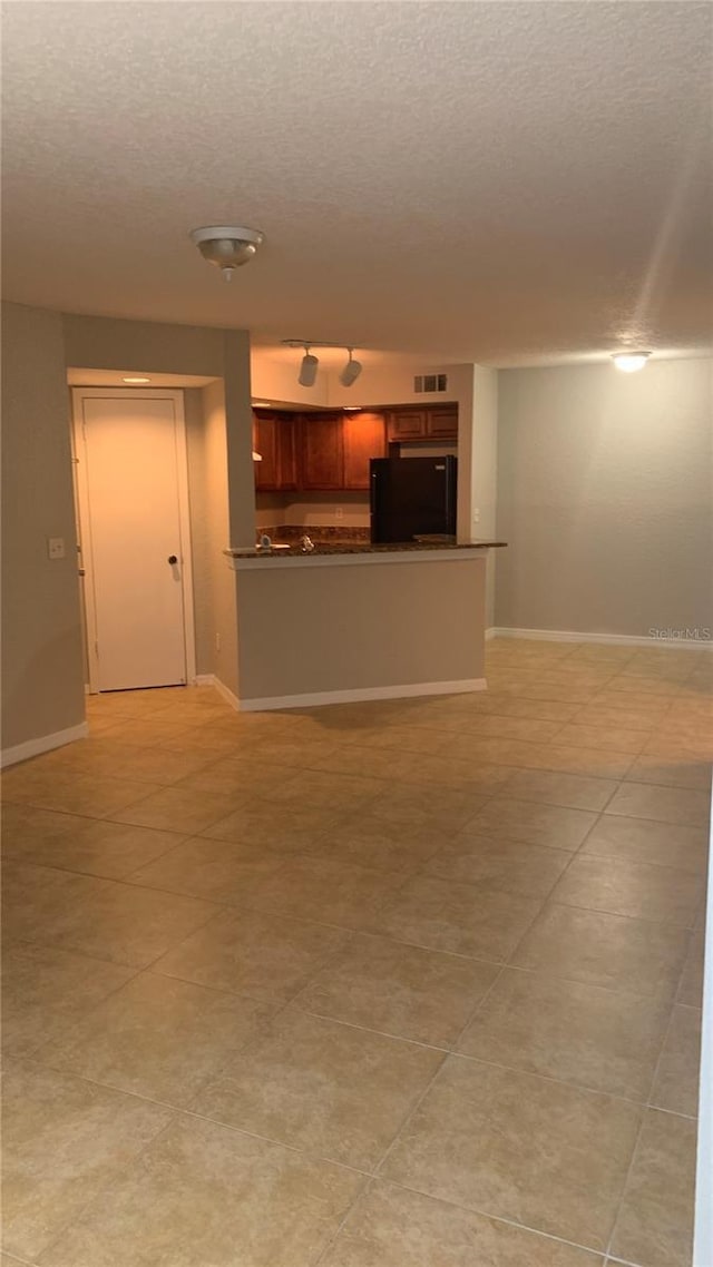 5725 Gatlin Ave Unit 315, Orlando, FL 32822 - unfurnished living room featuring a textured ceiling and light tile patterned floors