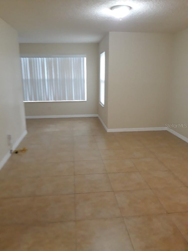 5725 Gatlin Ave Unit 315, Orlando, FL 32822 - empty room with light tile patterned flooring and a textured ceiling