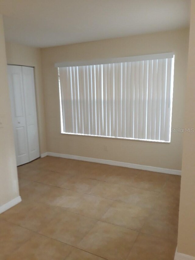 5725 Gatlin Ave Unit 315, Orlando, FL 32822 - unfurnished room featuring healthy amount of natural light and light tile patterned flooring