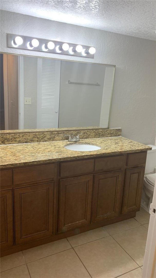 5725 Gatlin Ave Unit 315, Orlando, FL 32822 - bathroom with a textured wall, a textured ceiling, tile patterned flooring, and vanity