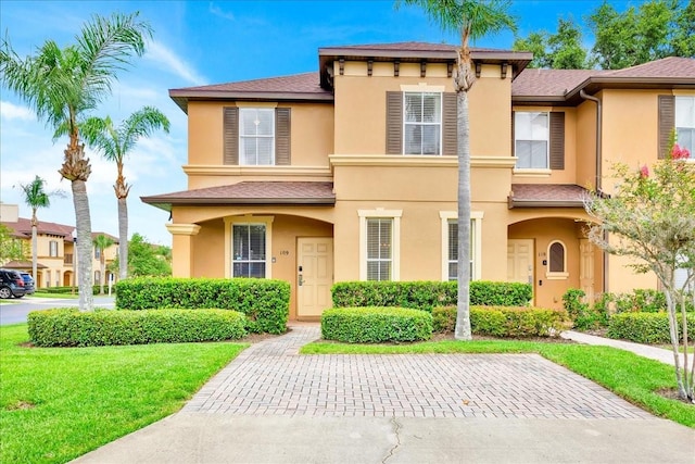 109 Cambria Ave, Davenport, FL 33897 - view of front facade with stucco siding, a front lawn, and a shingled roof