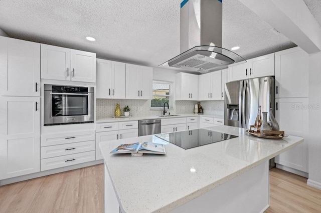 3029 Pinetree, Winter Haven, FL 33884 - kitchen with appliances with stainless steel finishes, island range hood, a textured ceiling, white cabinets, and a center island