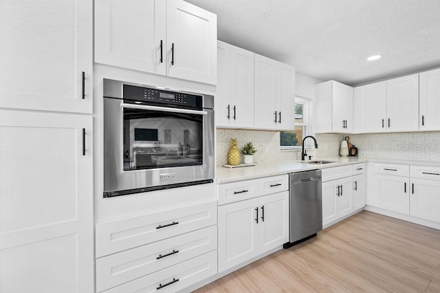 3029 Pinetree, Winter Haven, FL 33884 - kitchen with stainless steel appliances, a textured ceiling, light countertops, decorative backsplash, and white cabinets