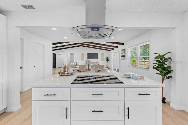 3029 Pinetree, Winter Haven, FL 33884 - kitchen with island range hood, light wood-type flooring, white cabinetry, cooktop, and light stone counters