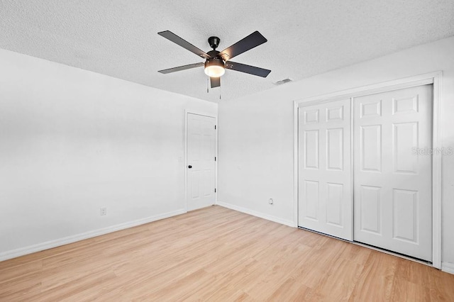 3029 Pinetree, Winter Haven, FL 33884 - unfurnished bedroom featuring light wood-type flooring, a textured ceiling, a closet, and a ceiling fan