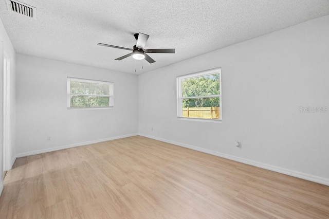 3029 Pinetree, Winter Haven, FL 33884 - unfurnished room featuring plenty of natural light, light wood-type flooring, ceiling fan, and a textured ceiling