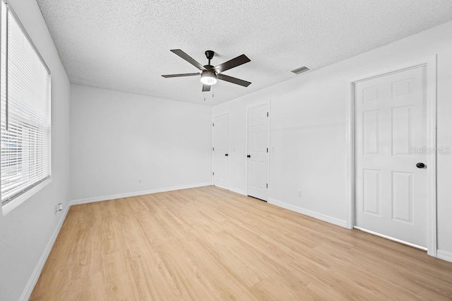 3029 Pinetree, Winter Haven, FL 33884 - unfurnished bedroom with light wood finished floors, a textured ceiling, and a ceiling fan