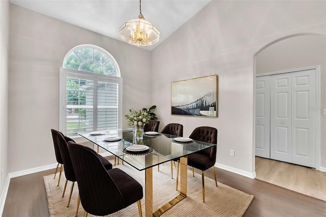 2675 Bond St, Clermont, FL 34711 - dining area with a chandelier, wood finished floors, lofted ceiling, and arched walkways