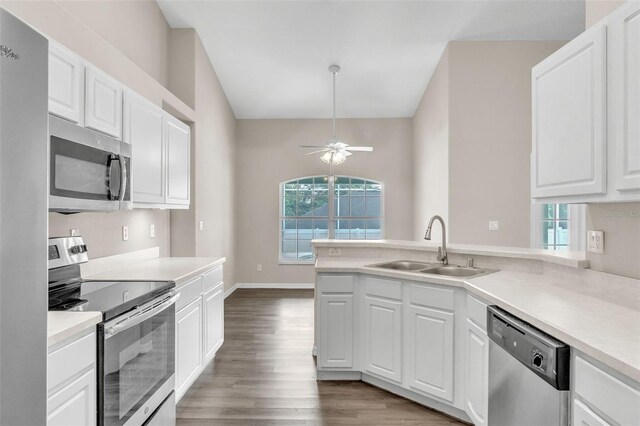 2675 Bond St, Clermont, FL 34711 - kitchen featuring stainless steel appliances, wood finished floors, white cabinets, and light countertops