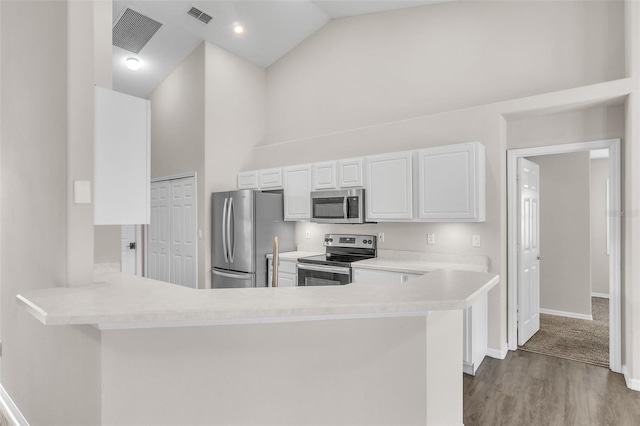2675 Bond St, Clermont, FL 34711 - kitchen featuring stainless steel appliances, white cabinets, light countertops, wood finished floors, and a peninsula