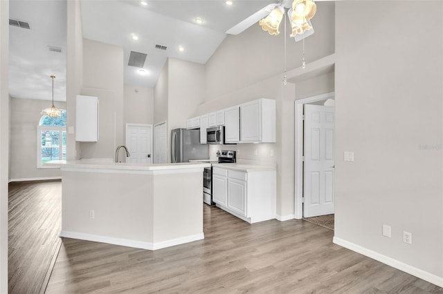 2675 Bond St, Clermont, FL 34711 - kitchen with appliances with stainless steel finishes, high vaulted ceiling, white cabinetry, ceiling fan, and light wood-style floors