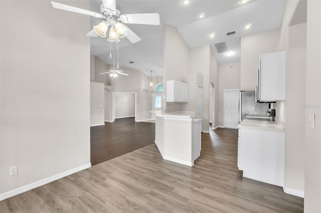 2675 Bond St, Clermont, FL 34711 - kitchen featuring high vaulted ceiling, a ceiling fan, light countertops, white cabinets, and wood finished floors